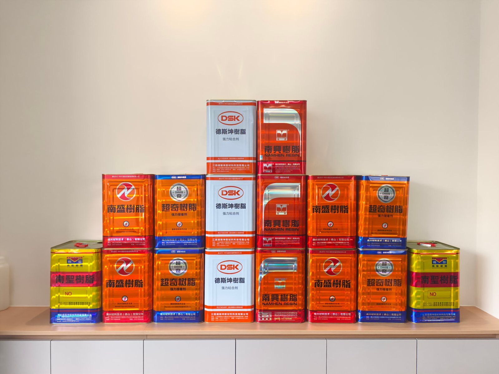 Professional arrangement of Desikun furniture adhesive products including drums, pails, and cartridges
